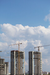 Construction of multi-storey buildings. Modern multi-storey building. Houses built of concrete and glass.