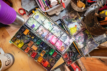 Watercolor paints started an open box at the artist's workplace.