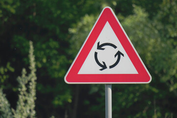 Close-up of a roundabout yield traffic sign attached to a metal pole	
