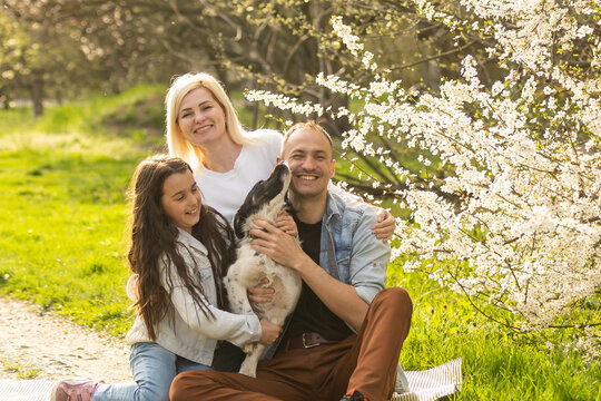 Family In A Blooming Spring Garden. Concept Of Happy Family