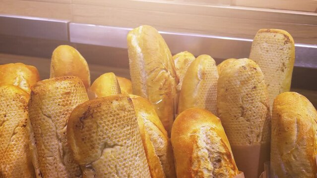 French baguettes stand in a basket in a bakery or supermarket. 