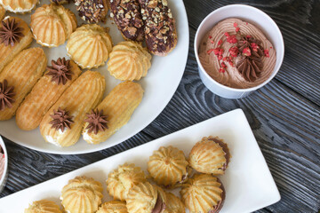 Homemade eclairs with cream. They lie on a plate. Custard pastries with cream. Close-up.