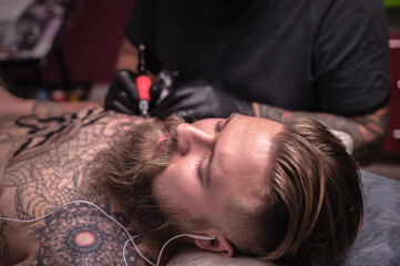 Fototapeta premium Tattoo specialist makes cool tattoo in tattoo parlor