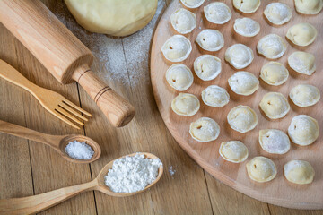 Delicious homemade dumplings with meat stacked on the kitchen board. Pelmeni