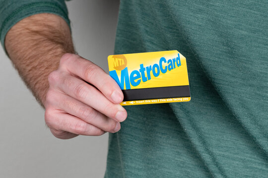 Adult Male Holding A NYC MetroCard With A Shallow Depth Of Field And Copy Space