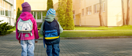 primary education - pupils with backpacks going to school in the morning. copy space