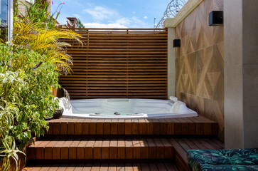 garden wooden deck with a jacuzzi at sunlight