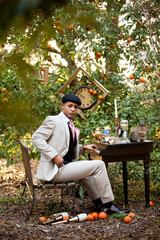 Alice in Wonderland inspired High Fashion shoot with Male Model posing in a suit Outside in Forest with Whimsical table and decor