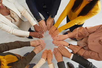 Close up top view of multiracial diverse businesspeople join hands in circle show team unity and...