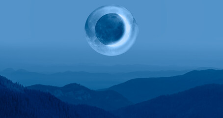  Beautiful landscape with blue misty silhouettes of mountains against A crescent in a crystal...