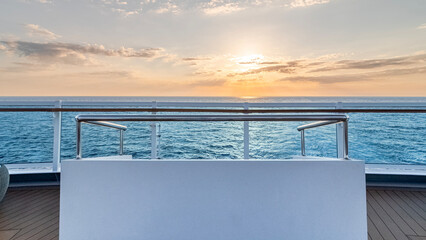 Vue d'un canapé sur le pont d'un navire de croisière au coucher de soleil dans le sillage du...