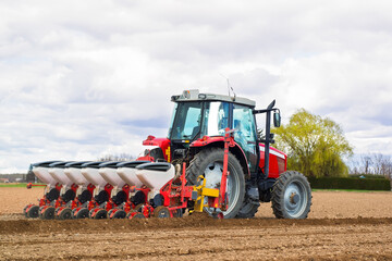 farmer on modern tractor with seed bins sowing  the plowed field  with farm equipment