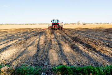 Obraz premium farmer on modern tractor with seed bins sowing the plowed field with farm equipment