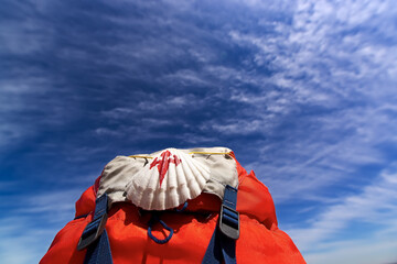Way of St James , Camino de Santiago ,scallop shell on backpack with blue sky and clouds  to...