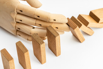 Wood hand Stopping Falling wooden Dominoes effect. Business Risk Management Solution and strategy Concept