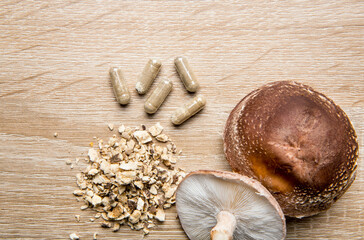 Shiitake Lentinus edoides mushroom supplement capsules with fresh Shiitake mushrooms and powdered...