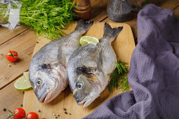 Raw peeled dorado fish with cooking ingredients. Fresh fish on a wooden background