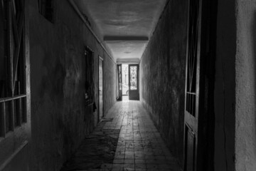 Photo inside the corridor of an old apartment building, the sun shines through the windows and front door - obrazy, fototapety, plakaty