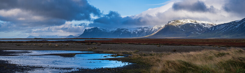 View during auto trip in West Iceland highlands, Snaefellsnes peninsula, Snaefellsjokull National Park. Spectacular volcanic tundra landscape with mountains, craters, lakes, gravel roads.