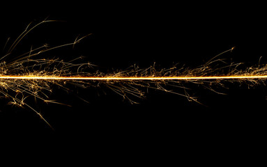 Sparkler trail of light with sparks in a straight line
