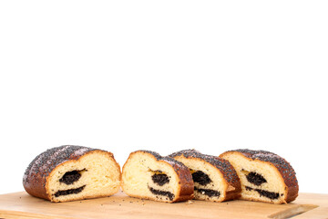 Several slices of delicious homemade poppy seed roll on a bamboo cutting board, close-up, isolated on a white background.