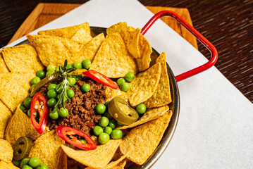 spicy chili made with tomato, beans, and ground beef with chips
