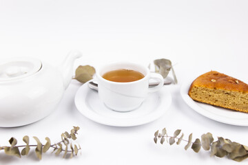 white tea set with teapot tea and saucers and pie for breakfast