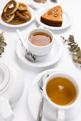 white tea set with teapot tea and saucers and pie for breakfast