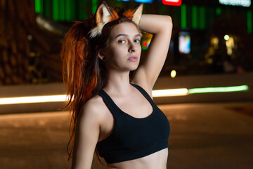 a girl with fiery red hair against the background of the lights of the night city.