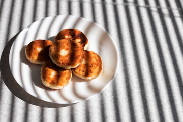 cheesecakes on a white plate on a table in the sun