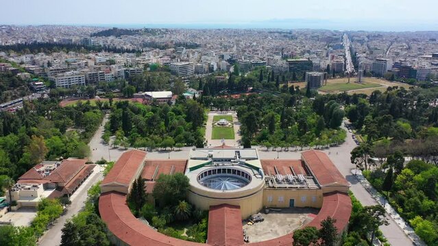 Aerial drone video of iconic public Zappio hall used for events and whole Athens cityscape at the background, Attica, Greece