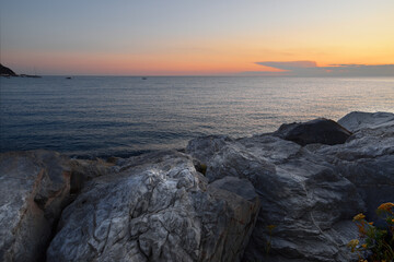 Obraz premium incredible colors and lights, a romantic sunset on the beach facing the sea in the magnificent Liguria
