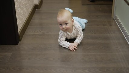 Newborn child learning crawling. Baby boy learning to crawl. Curious baby. Little boy is learning to crawl.