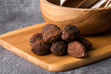 Black cardamom close up.
Dry black cardamom spice on a wooden background.