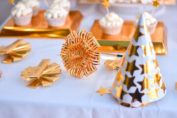 Decor on the corner of the table with sweets. Golden striped bow