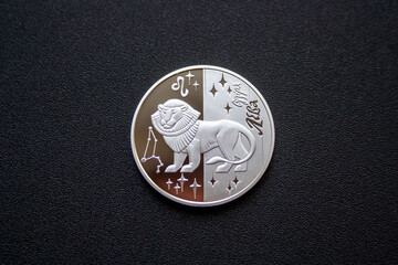 Silver Ukrainian five hryvnia coin with leo zodiac sign isolated on dark background