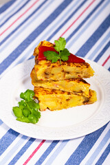 Traditional Spanish starter tortilla patatas served with red piquillo pepper.