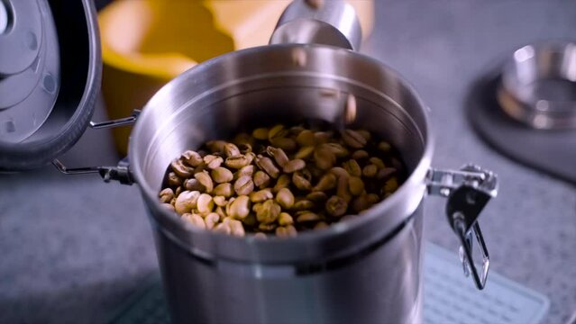 Footage of man pouring coffee bean into an air tight container. A person preparing an espresso drinks 