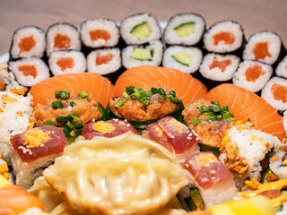 Sushi with salmon, rice, vegetable, mango and tuna. Arrangement of different sushi on a plate. Healthy sea food. 