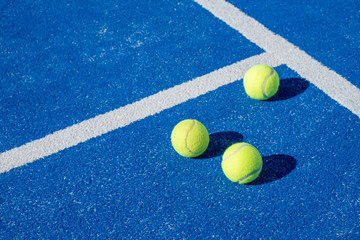Selective focus. Three balls an the net of a paddle tennis court