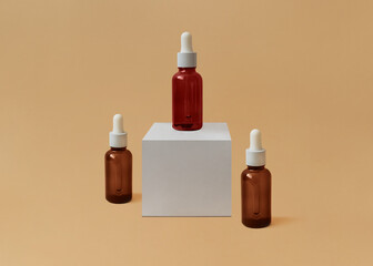 Cosmetics. Photo in minimal style. Three glass bottles with serum on beige background