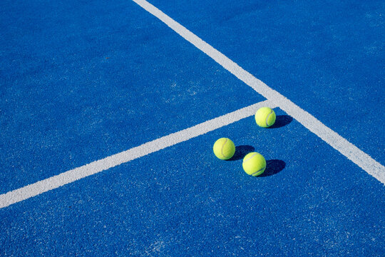 Selective focus. Three balls an the net of a paddle tennis court