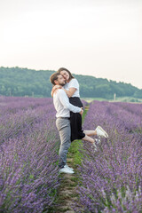 Beautiful happy couple, walking in purple lavender field, having fun in flower meadow. Romantic date