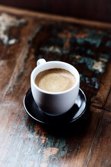 Cup of coffee on rustic wooden background.                                                                                            