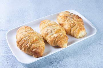 Gourmet cheese and sesame croissant, displayed on gray background