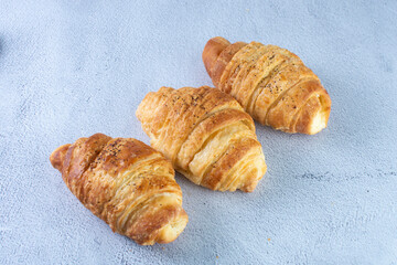 Gourmet cheese and sesame croissant, displayed on gray background