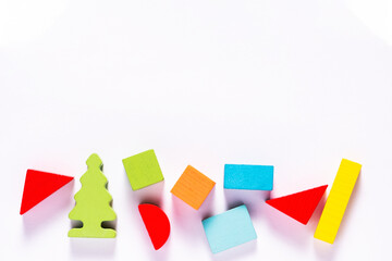 Top view on colorful toy bricks on a white wooden background. Toys in the table
