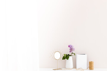 Lilac branch, notebook, mirror on a white wooden background. Spring background
