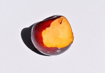 Bitten plum isolated on white background.