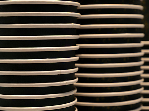 Stacks of the dark disposable paper cups, background